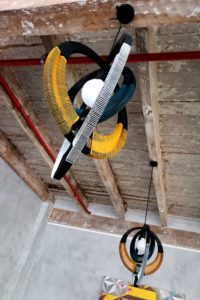 Image showcasing a project between Modern Gesture and Spier Art Academy. Modern Gesture Woven Necklace Pendant hanging from the ceiling